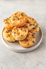 Savory zucchini muffins with cheese and seeds on a plate on white table background isolated. Healthy and quick morning breakfast