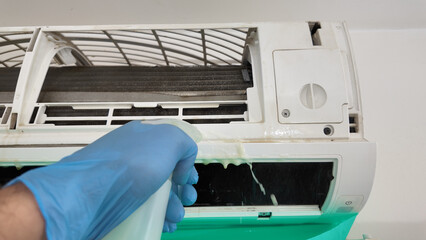 Man cleaning and maintaining air condition unit at Man cleaning and maintaining air condition unit...