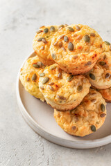 Savory zucchini muffins with cheese and seeds on a plate on white table background isolated. Healthy and quick morning breakfast