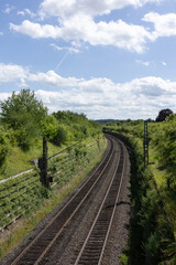 Obraz premium Railway tracks surrounded by greenery. 