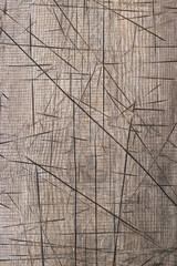 Old gray board with cracks and cuts close-up, rough texture of rough weathered board, vertical photo with abstract natural pattern