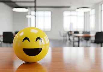 A happy smiley face emoji on a wooden table in an office