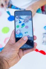 Person with mobile phone recording a woman working
