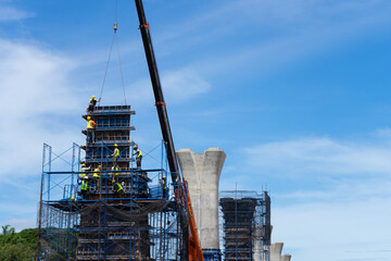 Workers construct bridge piers for a railway.