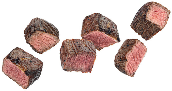 Medium rare steak pieces, sliced grilled beef cubes isolated on white background