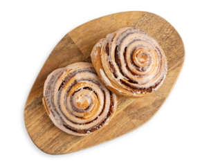 Top view of two delicious homemade cinnamon rolls bun served on brown wooden cutting board isolated on white background used as sweet baked pastry dessert for breakfast or comfort food for brunch