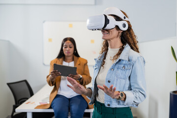 Diverse coworkers gesturing with VR headset, using tablet at office whiteboard, copy space