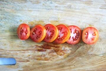 slice of tomato on a wooden cutting board