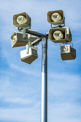 Alert system speakers mounted on tall pole against clear blue sky during daytime enhance safety in public areas