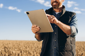 Farmer using digital tablet in wheat field for smart agriculture management