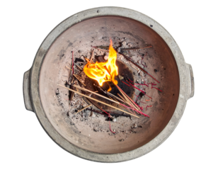 Incense sticks burning with visible flame inside traditional clay pot used in rituals on isolated white background