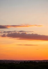 Fototapeta premium Dramatic sunset with layered clouds and vibrant orange sky at twilight time