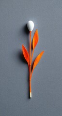 Abstract floral composition. White bud atop orange stem with vibrant orange leaves against a smooth gray background, artfully arranged and vertically oriented