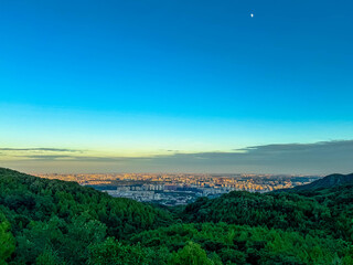 Sunset Over Mountain Ridge with Distant City Skyline