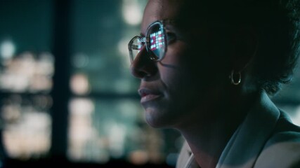 Close-up of female stock market analyst working in skyline office at night - Powered by Adobe