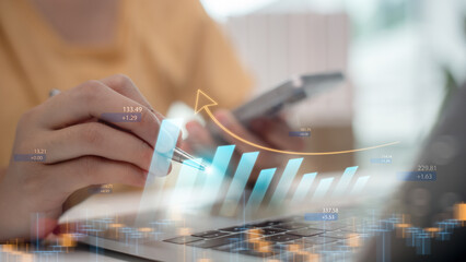 Hand analyzing financial data on laptop with upward bar graph and digital numbers. Concept of investment, stock market growth, trading, fintech analytics, and financial success.