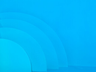 Clean and minimal abstract view of swimming pool steps and curved shapes in vivid blue tones. 