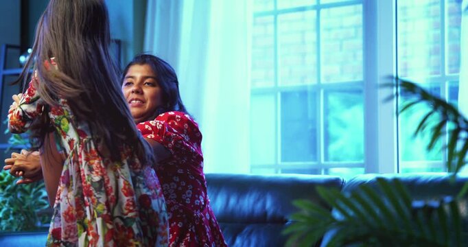 Indian little sisters fighting on sofa at home in playful argument, Asian sibling girls hitting each other during fun indoor moment, childhood emotions, real family bonding, candid lifestyle scene