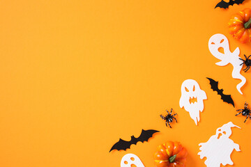 Happy Halloween flat lay composition with ghosts, spiders, bats, pumpkins on orange background. Top...