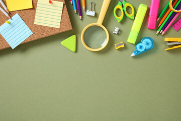 Flat lay colorful stationery on green background, featuring sticky notes, pencils, scissors, and highlighters.