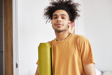 Closeup of handsome healthy sporty guy fitness instructor with afro hair on his way to gym or yoga...