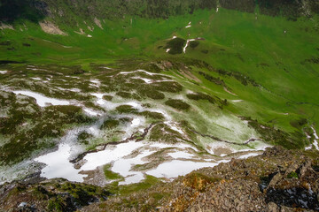 glacial mountain river, green hills in the distance