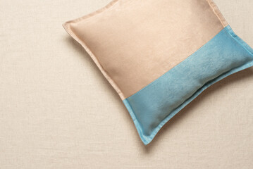 Beige blue soft pillow flat lay on beige textile background, top view, flat lay, minimal interior