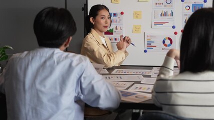 Asian business colleagues working together on project planning, analyzing data chart and sticky notes on board, team collaboration, office brainstorming session, diverse professionals in business - Powered by Adobe