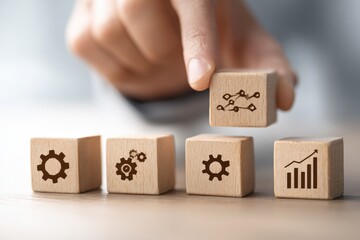 Hand placing wooden block with graph onto others showing gears and bar graph