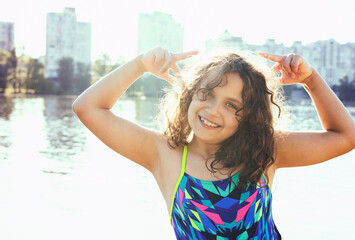 Curly baby girl on the sea background