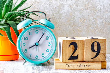 Wooden calendar with the date October 29.Monthly calendar for planning and management concept with alarm clock on wooden background