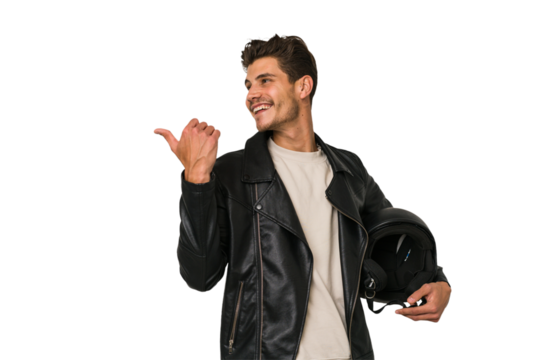 Young caucasian man holding a motrbike black helmet isolated points with thumb finger away, laughing and carefree.