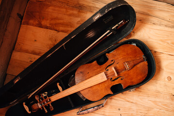 Brown violin in case over wooden background. Art and music background. Favorite string instrument. Top view.