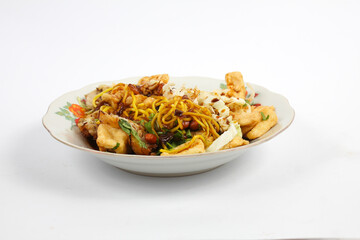 traditional food tofu kupat(tahu kupat). Food containing yellow noodles, pieces of fried tofu, peanuts, fritters, cabbage, ketupat and covered in sweet peanut sauce.