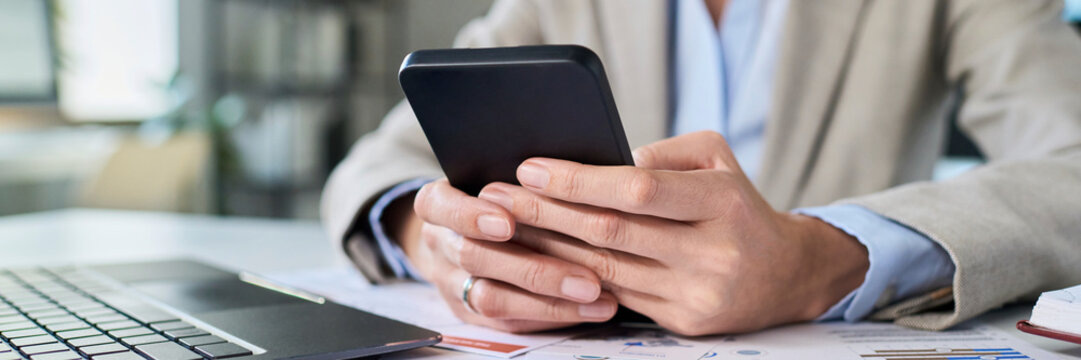 Manager working at office desk using smartphone for business communication
