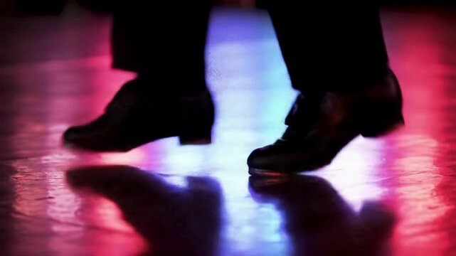Heel click tap dancer on colorful spotlight stage