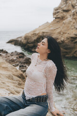 Young woman modeling on the rocks of a beach