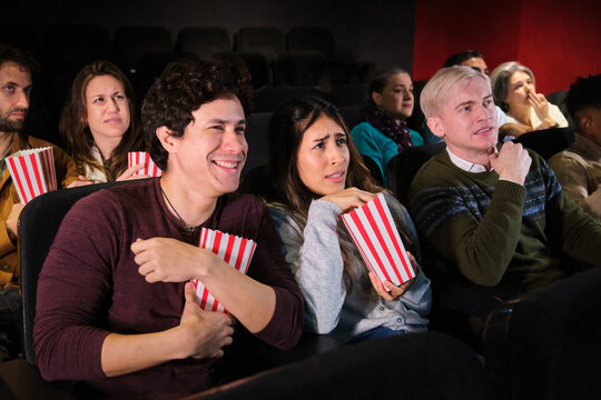 Group of friends enjoying a movie night at the cinema, experiencing different emotions