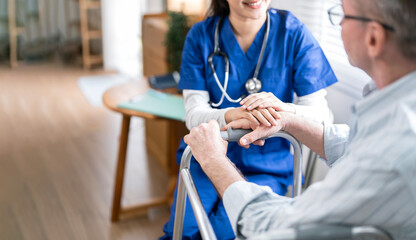 Female doctors holding older man patients hand to encouraging with care and encouragement while...