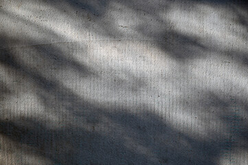 Shadows cast on textured concrete surface during late afternoon light in urban environment