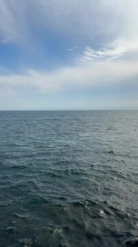 Ocean waves and sky, vertical video.