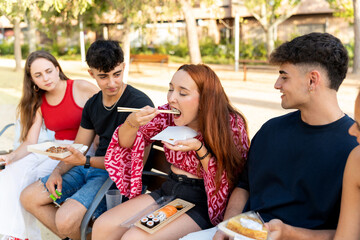 Young people enjoying take away food in a park
