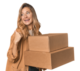 Blonde Caucasian moving with large boxes points with thumb finger away, laughing and carefree.