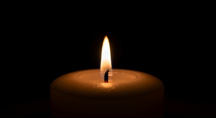 An intimate and hypnotic macro cinemagraph of a candle flame flickering gently in the dark.