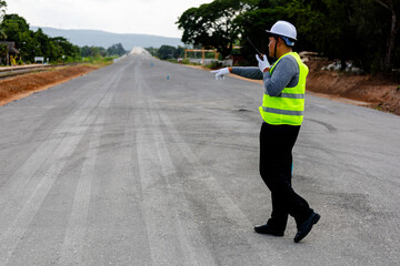 A engineer   on a vast road construction site. Traffic cones and barriers are, signifying   area  in large infrastructure projects.