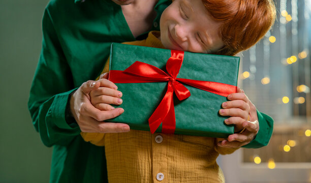 Mother and red-haired child sharing a Christmas gift at home