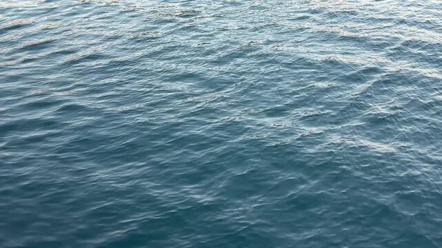 Blue water calm ripples surface.