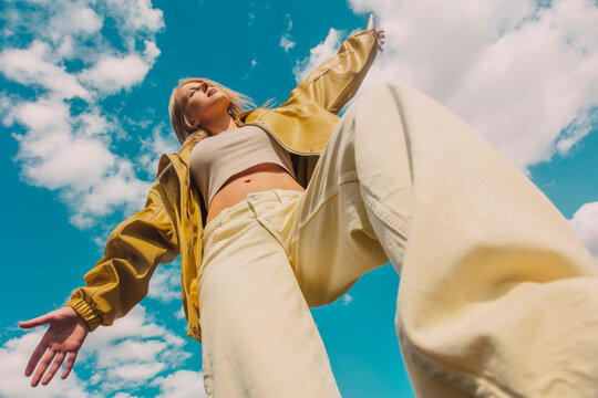 Stylish woman posing confidently outdoors in low angle view