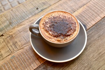 Cup of cappuccino with cinnamon on top. Warmth, comfort, and aromatic coffee moment.