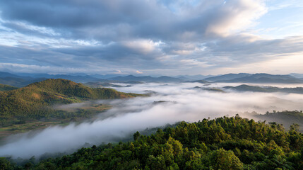 Obraz premium A breathtaking view of rolling hills enveloped in mist under a cloudy sky, showcasing the serene beauty of nature's landscape.